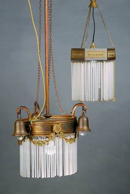 Zwei Deckenlampen, deutsch, um 1910, Messingblech geprägt, mit reichem Gehänge, hohle Glasstäbe, abstr. geom. Dekor, 1 x vier Brennstellen, H. ...
