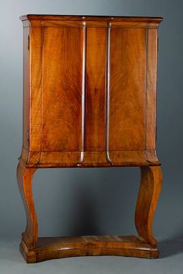 Stollenschrank, deutsch, um 1925/30, Korpus HH/WH, Nußbaum, 2-türig, Kopf 3-fach getreppt,Beine geschweift, in Voluten auslaufend, Furniersch., st. ...