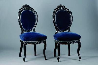 6 Stühle, deutsch, um 1835/40, schwarz gefasst, allseitig geschweift u. gerieft, Lehne m. reicher Blüten und Akanthusblattschnitzerei, blauer Bezug ...