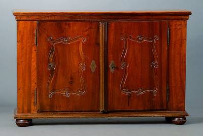 Kleine Anrichte, um 1730/40, aus alten Teilen zusammengesetzt, Nußbaum, 2-türig, Flachschnitzereien in Form v. Voluten, Gebr. -Sp., teilrest., ca. ...