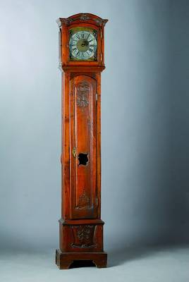 Standuhr, um 1770, Nußbaum/Eiche verziert und geschnitzt, Sockel gekürzt, in Türe Maskeronenpaar, alter Wurmbefall, orig. Beschläge, im Giebel ...