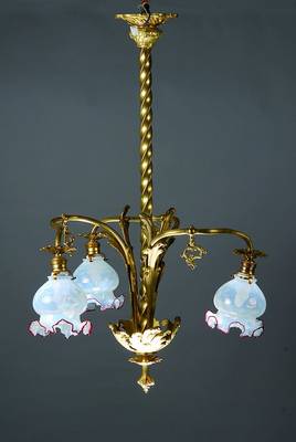 Deckenlampe, Frankreich, um 1890, Gelbgußmonturen mit in sich gedrehtem Mittelstab und drei gebogenen Armen mit Milchglasschirmen mit rotem Rand, ...