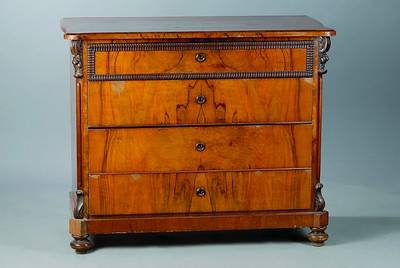 Kommode, um 1840/50, Nußbaum/Wurzelnußfurnier gesp. verlegt, 4 -schübig, abgerundete Ecken, sparsam aufgesetzte Akanthusblattschnitzereien, l. ...