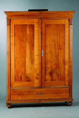 Kleiderschrank, wohl Schwarzwald, um 1880/90, Kirschbaum/Esche und Birnenholz, 2-türig, Fußschublade, sog. Spaltschrank, Beschläge sek., Kopf ...
