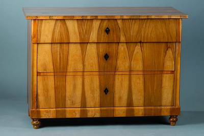 Biedermeier-Kommode, um 1840, Nußbaumfurnier, 3-schübig, Furnier vielfach gesp. verlegt, sehr schönes Furnierbild, teilrest., Teile ergänzt, ...