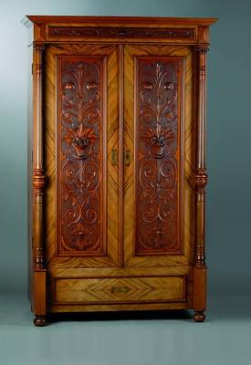 Gründerzeitschrank, um 1880, Nußbaum/Wurzelnußfurnier, 2-türig, Fußschublade, Inlets m. reicher floraler Schnitzerei, Lisenen m. Säulen, diese ...