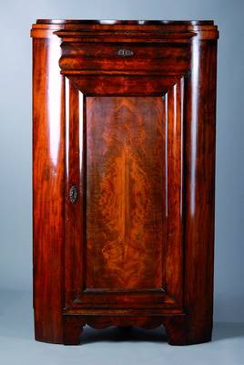 Eckschrank, deutsch, um 1830/40, Mahagonifurnier, gesp. verlegt, 1-türig, Zargegeschweift, abgerundete Ecken, l. Furniersch.,st. Gebr.-Sp., ca. ...
