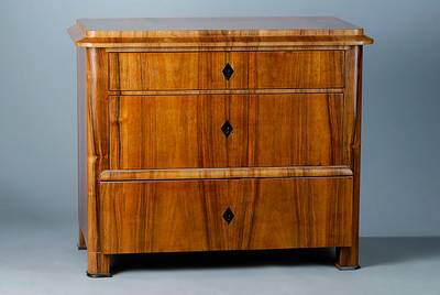 Kommode, Biedermeier, um 1830/40, Nußbaum, 3-schübig, abgerundete Ecken, l. verzogen, Teile ergänzt, ein Furnierstück fehlt, Gebr. -Sp., ca. ...