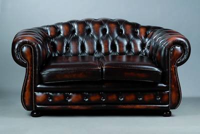 Chesterfield Sofa, nach englischem Vorbild, 20. Jh., 2-Sitzer, braunes Kunstleder, lose Sitzkissen, geheftet und genoppt, st. Gebr.- Sp., ca. ...