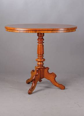 Ovaler Tisch, um 1860/70, Pyramidenmahagoni,reich gedrechselte Säule, stehend auf 3 geschweiften Tischbeinen, seltene kleine Form,ca. 74x85x54 cm