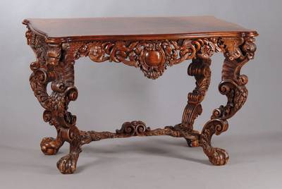 Prunktisch, deutsch um 1880/90, Nussbaum massiv, Platte in Wurzelnussfurnier, 8-fach geschweift u. 8-fach gekröpft, Zargen sehr üppig geschnitzt u. ...