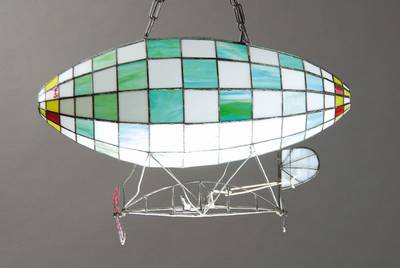 Deckenlampe, in Form eines Zeppelins, 2. Hälfte 20. Jh., Bleiverglasung, eine Brennstelle, ca. 85x60x27 cm, Funktion nicht geprüf.