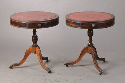 Zwei Beistelltische, sog. Drum Table, England,20. Jh., Mahagoni, je mit drei Schubladen, Lederplatten, sehr dekorativ, Gebr.-Sp., rest., je ca. D. 50 ...