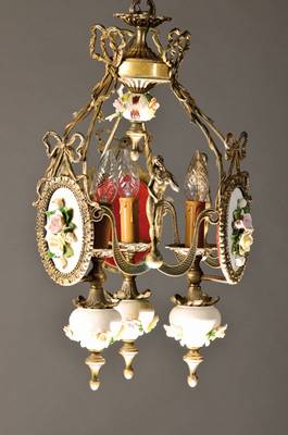 Deckenlampe im Klassizismus, wohl Italien, 60er Jahre, Metallguß mit vollplastischen Frauenakten, Porzellaneinsätzen, applizierte Blumen, bemalt, ...
