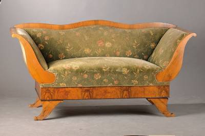 Biedermeiersofa, südwestdeutsch um 1830, Nussbaum gespiegelt verlegt, Lehne geschweift, Armlehne weit ausladend, Beine füllhornförmig, Reste alten ...