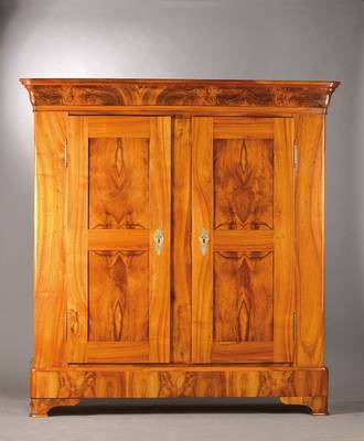 Biedermeierschrank, wohl Bodensee um 1820/30, Nussbaum massiv bzw. Wurzelnuss doppelt gespiegelt furniert, ausladendes Gesims u. Wangen, Türen u. ...