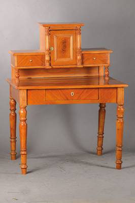 Damenaufsatzschreibtisch, wohl aus alten Teilen um 1870 umgebaut, Kirschbaumfurnier z.T. gespiegelt verlegt, podestformiger Aufsatz, 1-türig, u. ...