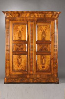 Biedermeierschrank, wohl Baden, um 1835/40, Nussbaum furniert u. massiv, vielfach mit Karnies profiliert, seitl. angesetzte Säulen, Rahmen auf ...