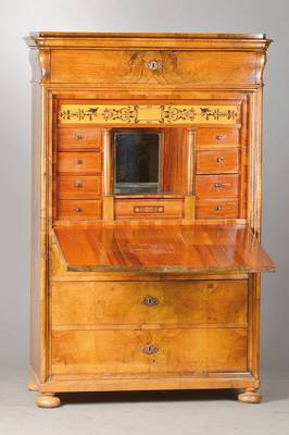Standsekretär, wohl Pfalz, um 1840/50, Nussbaum- bzw. Wurzelnussfurnier auf Weichholzkorpus, Kopf vielfach profiliert, Kasten tiefen-profiliert u. ...