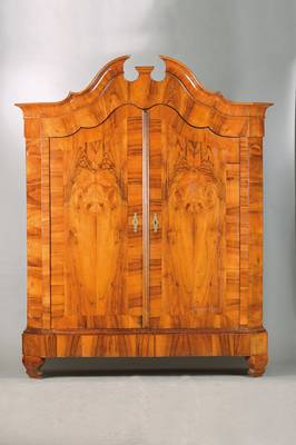 Barockschrank, wohl Schleswig-Holstein, um 1770/80, Nussbaum- bzw. Wurzelnussfurnier gespiegelt verlegt auf Eichekorpus, geschweift gekröpfter ...
