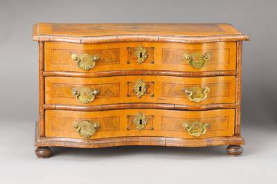 Miniaturkommode, wohl westdeutsch, um 1750, Nussbaum- bzw. Wurzelnussfurnier auf Weichholzkorpus, Pflaumenbänder u. Ahornfilets, vielfeldriger ...
