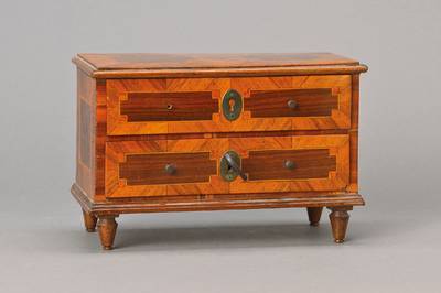 Barockmodellkommode, süddeutsch, um 1750/60, Nussbaumfurnier vielfach auf Kreuzfuge verlegt, geometrisierende verkröpfte Felder in Ahornfilets mit ...