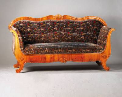 Biedermeiersofa, süddeutsch, um 1830, Nussbaum massiv, z.T. furniert auf Weichholzkorpus, allseitig geschwungene Form, seitl. Rosetten-Schnitzerei ...