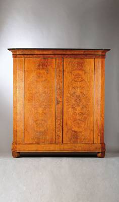 Biedermeierschrank, wohl Niederrhein, um 1810/20, ausgesuchtes Blumenesche-Furnier, auf Weichholzkorpus, 2-türig, weit ausladendes Hohlkehlengesims, ...