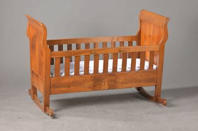 Kinderwiege, süddeutsch, um 1820/30, Nussbaum u. Weichholz, Kopf- u. Fußteil ausgeschweift, Füllung in gespiegeltem Nussbaumholz, Kufen ...