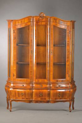 Aufsatzvitrine im Barockstil, Frühes 20.Jh., Nussbaumfurnier auf Buchekorpus, 3-türig, 3- seitig verglast, bombierter Unterbau mit 6 Schubladen u. ...