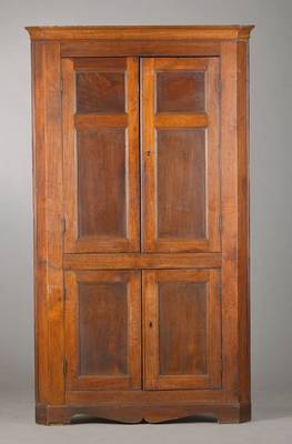 Eckschrank, deutsch, um 1830, Nussbaum massiv, komplett auf Rahmen gearbeitet, 2- geschossig, insg. 4-türig, Sockelzarge symmetrisch beschnitzt, ...