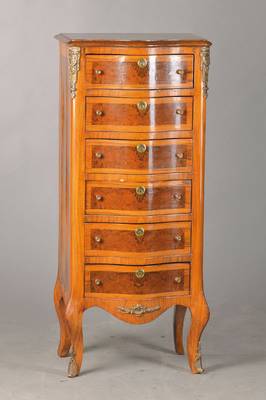 Kleiner Schubladenschrank, sog. Chiffonieré bzw. Pfeilerkommode, 70er Jahre, Nussbaum- bzw. Wurzelnussfurnier, Front geschweift, Messingappliken, ...