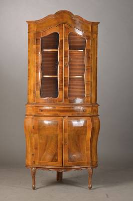 Aufsatzvitrine, wohl Italien, 60/70er Jahre, im Barockstil, Nussbaumfurnier, Korpus vielfach bombiert u. geschweift, Unter- u. Oberteil je 2-türig, ...