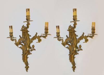 Paar Wandleuchten, Rokokostil, Mitte 20. Jh. Gelbguß in Rocaillenform, je drei Brennstellen, Elektr. nicht geprüft, H. ca. 60cm