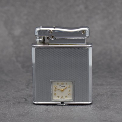 COLIBRI Monopol Benzinfeuerzeug mit eingebauter Uhr, original Etui & Papieren, Schweiz um 1950, Handaufzug, verchr. Geh., Aufzug d. Uhr & Befüllung ...