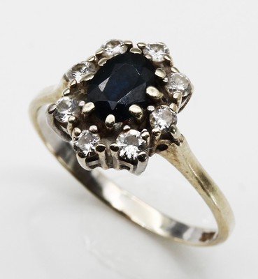 14 kt Gold Saphir-Diamant-Ring, WG 585/000,ovalfacett. Saphir ca. 1.0 ct, 7 Brillanten zus. ca. 0.35 ct Weiß/si und 1 Glasstein, total ca. 2.5 g, ...