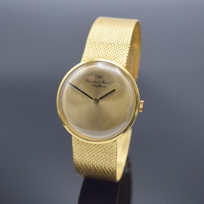 IWC Herrenarmbanduhr in GG 750/000, Handaufzug, Schweiz um 1964, orig. Milanaiseband, 3-teil. Geh., Boden & Glasrand aufgedr., gold. ...