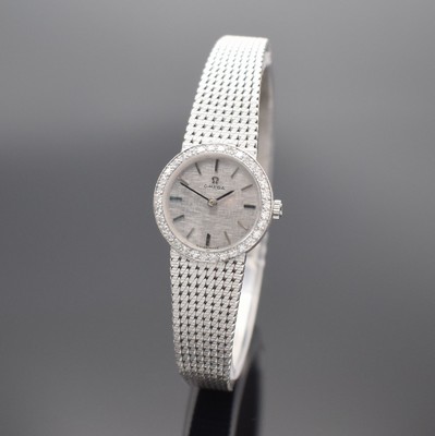 OMEGA Damenarmbanduhr in WG 750/000 mit Diamanten, Schweiz um 1967, Handaufzug, Boden aufgedr., Lünette aufw. m. Diamanten bes., silb. Zifferbl. m. ...