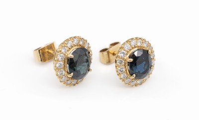 Paar 18 kt Gold Saphir-Brillant-Ohrstecker, GG 750/000, je mit einem ovalfacett. Saphir zus. ca. 3.0 ct umgeben von je 17 Brillanten zus. ca. 0.45 ct ...