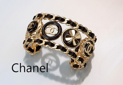 CHANEL Armreif, Metall verg., B. ca. 3 cm, eingearbeitetes Lederband, Chanel-Logo mit schwarzem Lack, Blüten, D. ca. 5.5 cm, sign., in orig. Karton