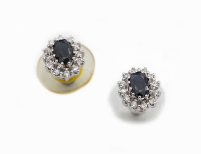 Paar 14 kt Gold Saphir-Brillant-Ohrstecker, WG 585/000, 2 ovalfacett. Saphire zus. ca. 1.10 ct, umgeben von insg. 24 Brillanten zus. ca. 0.24 ct ...