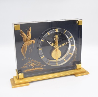 Jaeger-LeCoultre Marina 8-Tage Tischuhr mit Stabwerk Referenz 350, Schweiz um 1960, Plexiglas-Geh. auf verg. Stand, gold. Paradiesvogel-Motiv vor ...