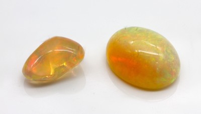 Konvolut 2 lose Opal Cabochons: 1 x ca. 10.9 ct, Farbspiel in Orange Grün; 1 x 5.30 ct, Farbspiel in Orange Grün