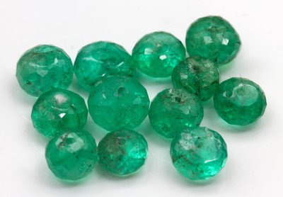 12 lose facett. Smaragd-Rondelle zus. ca. 14.7 ct, gebohrt, z. mit Kerben/besch.