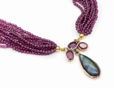 11-reihiges Granat-Collier, Mittelschließe GG 585/000, bes. mit 3 ovalfacett. Rhodolite zus. ca. 3,00 ct, Labradorit Cabochon in Tropfenform ca. ...