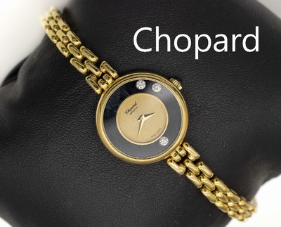 18 kt Gold CHOPARD Damenschmuckuhr, GG 750/000, aus der Serie "Happy Diamonds", z.T.schwarzes Ziffernblatt mit 3 bewegl. Brillanten unter ...