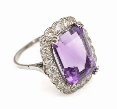 Platin Amethyst-Brillant-Ring, Pt(gepr.), mittiger Amethyst im Emerald-Cut ca. 12.00 ct umgeben von 20 Brillanten zus. ca. 1.20 ct Weiß/si, RW 57, ...