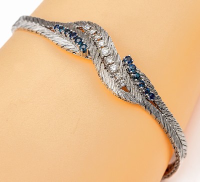 14 kt Gold Saphir-Brillant-Armband, WG 585/000 strukt., in Flechtoptik, 12 oval facett. Saphire zus. ca. 0.60 ct, mittig 9 Brillanten zus. ca. 0.45 ...