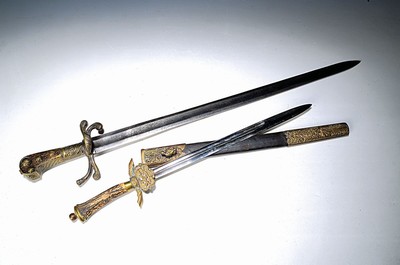 2 Hirschfänger, Mitteleuropa, Ende 19.Jh., Horn- bzw.- Hornschalengriff, Messingbeschläge z.T. mit Jagdmotivik, 1x mit Scheide, Alterssp., L. ges. ...