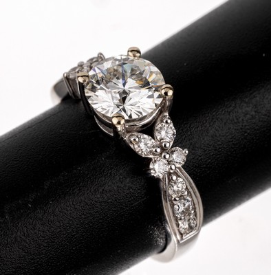 18 kt Gold Brillant-Ring, WG 750/000, mittig Brillant ca. 1.34 ct Weiß(H)/si1, 14 Brillanten zus. ca. 0.44 ct (grav.) Weiß/si, RW 54, ca. 3.8 g